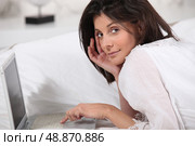 brunette lying in bed with laptop. Стоковое фото, агентство Ingram Publishing / Фотобанк Лори