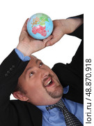 Businessman collapsing under globe. Стоковое фото, агентство Ingram Publishing / Фотобанк Лори