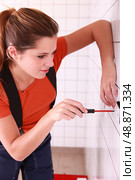 Female electrician installing a wall socket. Стоковое фото, агентство Ingram Publishing / Фотобанк Лори