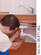 Plumber screwing siphon. Стоковое фото, агентство Ingram Publishing / Фотобанк Лори