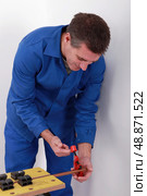 Man tightening vice on to copper pipe. Стоковое фото, агентство Ingram Publishing / Фотобанк Лори