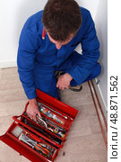 Artisan knelt by red tool box. Стоковое фото, агентство Ingram Publishing / Фотобанк Лори
