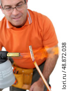 Plumber soldering pipe. Стоковое фото, агентство Ingram Publishing / Фотобанк Лори
