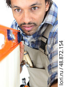 Tradesman using a bubble level. Стоковое фото, агентство Ingram Publishing / Фотобанк Лори