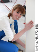 Woman wallpapering front room. Стоковое фото, агентство Ingram Publishing / Фотобанк Лори