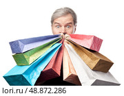 surprised mature man holding shopping bags near face isolated on white background. Стоковое фото, агентство Ingram Publishing / Фотобанк Лори