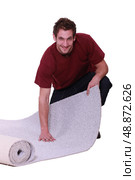 Unrolling a carpet. Стоковое фото, агентство Ingram Publishing / Фотобанк Лори