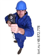 high angle shot blue collar using drill. Стоковое фото, агентство Ingram Publishing / Фотобанк Лори