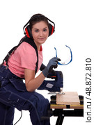 Young woman using miter saw. Стоковое фото, агентство Ingram Publishing / Фотобанк Лори