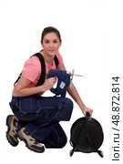 Handywoman holding a jigsaw and an extension cord. Стоковое фото, агентство Ingram Publishing / Фотобанк Лори
