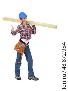 Woman carrying two planks of wood. Стоковое фото, агентство Ingram Publishing / Фотобанк Лори