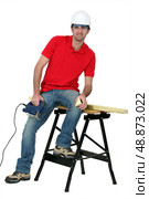 Man cutting a piece of wood with a jigsaw. Стоковое фото, агентство Ingram Publishing / Фотобанк Лори