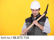 craftsman holding pickaxe against yellow background. Стоковое фото, агентство Ingram Publishing / Фотобанк Лори