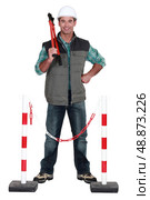 Tradesman standing in front of a barrier. Стоковое фото, агентство Ingram Publishing / Фотобанк Лори