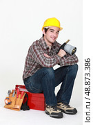 Tradesman holding a blowtorch and sitting on his toolbox. Стоковое фото, агентство Ingram Publishing / Фотобанк Лори
