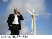Man on mobile phone next to wind turbine. Стоковое фото, агентство Ingram Publishing / Фотобанк Лори
