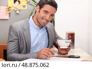 Businessman working in his kitchen with a cup of coffee. Стоковое фото, агентство Ingram Publishing / Фотобанк Лори