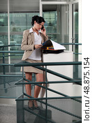 Executive with folders on the phone. Стоковое фото, агентство Ingram Publishing / Фотобанк Лори
