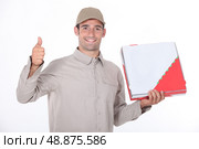 a delivery man holding a packet and doing thumbs up. Стоковое фото, агентство Ingram Publishing / Фотобанк Лори