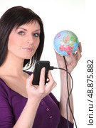 Woman plugging her cellphone into the world. Стоковое фото, агентство Ingram Publishing / Фотобанк Лори