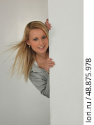 Woman sticking out behind the wall. Стоковое фото, агентство Ingram Publishing / Фотобанк Лори