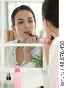 Woman applying make-up. Стоковое фото, агентство Ingram Publishing / Фотобанк Лори