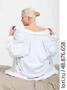 A female model taking her bathrobe off on her bed. Стоковое фото, агентство Ingram Publishing / Фотобанк Лори