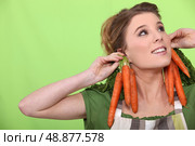 a female cook wearing carrots as earrings. Стоковое фото, агентство Ingram Publishing / Фотобанк Лори