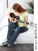 Woman playing electric guitar. Стоковое фото, агентство Ingram Publishing / Фотобанк Лори