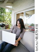 Woman using her laptop on her veranda. Стоковое фото, агентство Ingram Publishing / Фотобанк Лори