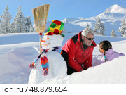 Father and daughter with snowman. Стоковое фото, агентство Ingram Publishing / Фотобанк Лори