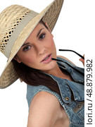 Flirtatious brunette wearing straw hat. Стоковое фото, агентство Ingram Publishing / Фотобанк Лори