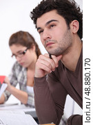 A pensive student at the library. Стоковое фото, агентство Ingram Publishing / Фотобанк Лори