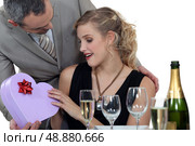 Boyfriend surprising girlfriend with heart-shaped box. Стоковое фото, агентство Ingram Publishing / Фотобанк Лори