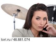 beautiful brunette with drums in background. Стоковое фото, агентство Ingram Publishing / Фотобанк Лори