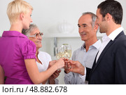 Men and women clinking glasses of champagne. Стоковое фото, агентство Ingram Publishing / Фотобанк Лори