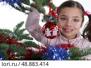 schoolgirl near decorated Christmas tree. Стоковое фото, агентство Ingram Publishing / Фотобанк Лори