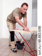 Man gluing paper together. Стоковое фото, агентство Ingram Publishing / Фотобанк Лори