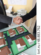 Close-up of architects shaking hands. Стоковое фото, агентство Ingram Publishing / Фотобанк Лори