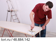 Artisan gluing wallpaper. Стоковое фото, агентство Ingram Publishing / Фотобанк Лори
