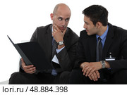 Businessmen discussing a file. Стоковое фото, агентство Ingram Publishing / Фотобанк Лори