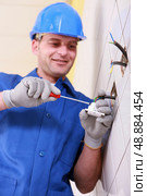 Electrician wiring a continental wall socket. Стоковое фото, агентство Ingram Publishing / Фотобанк Лори