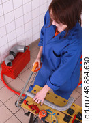 Female plumber sawing pipe. Стоковое фото, агентство Ingram Publishing / Фотобанк Лори