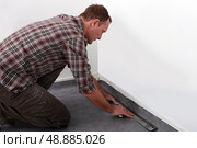 Tradesman laying down linoleum flooring. Стоковое фото, агентство Ingram Publishing / Фотобанк Лори