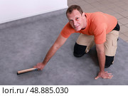 Man fitting a linoleum floor. Стоковое фото, агентство Ingram Publishing / Фотобанк Лори