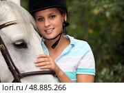 Young woman caressing her horse. Стоковое фото, агентство Ingram Publishing / Фотобанк Лори
