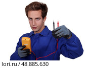 an electrician using an ammeter. Стоковое фото, агентство Ingram Publishing / Фотобанк Лори