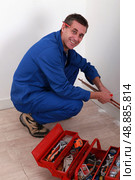 Plumber kneeling by tool box. Стоковое фото, агентство Ingram Publishing / Фотобанк Лори