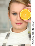 Woman covering her eye with orange slice. Стоковое фото, агентство Ingram Publishing / Фотобанк Лори