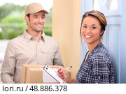 Delivery man and young woman. Стоковое фото, агентство Ingram Publishing / Фотобанк Лори